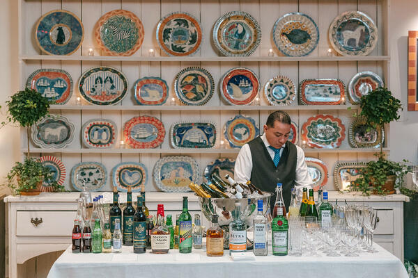 Robina’s Dinner Party, a pattern from the collection, celebrates one of Kemp’s favorite ceramicists, Robina Jack, depicting her glorious hand-painted plates, shown here on display in the Warren Street Hotel’s Orangery